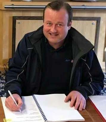 Tom Gerard signing his franchise agreement with Autosmart